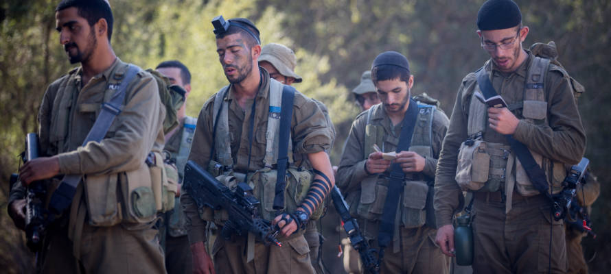 Religious IDF soldiers pray during training.