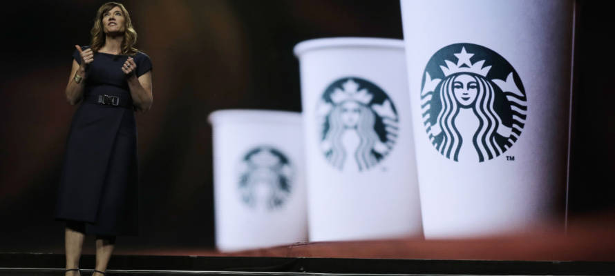 Michelle Burns, Starbucks senior vice president for coffee and tea, stands next to an image of Starbucks cups as she speaks Wednesday, March 20, 2019, during the company's annual shareholders meeting in Seattle.