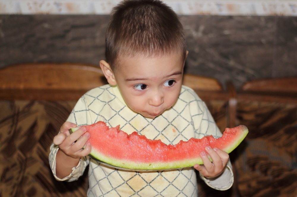 little boy eating watermelon