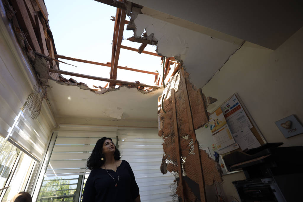 A woman looks at the damage to a house in Sderot, Israel, after it was hit by a rocket fired from Gaza Strip, Nov. 12, 2019.