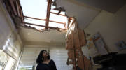 A woman looks at the damage to a house in Sderot, Israel, after it was hit by a rocket fired from Gaza Strip, Nov. 12, 2019.