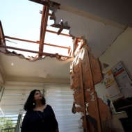 A woman looks at the damage to a house in Sderot, Israel, after it was hit by a rocket fired from Gaza Strip, Nov. 12, 2019.