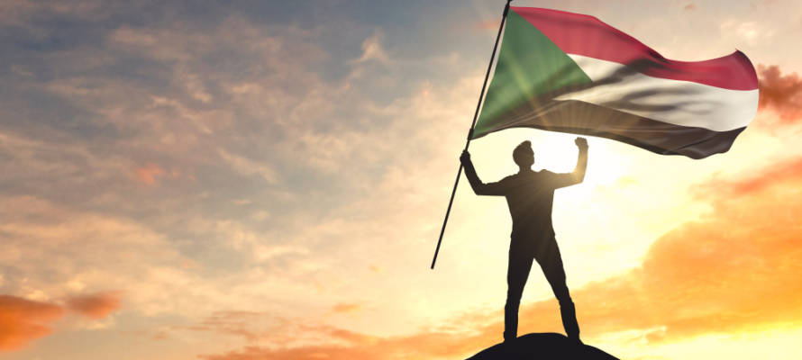 Man waving Sudanese flag (Shutterstock)