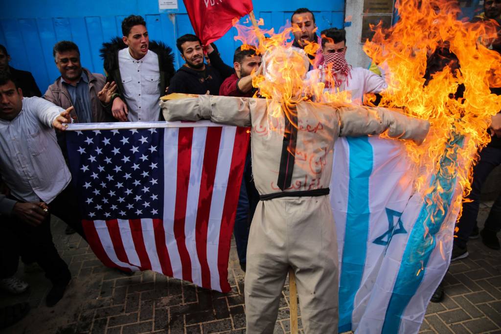 Palestinians burn an effigy of Donald Trump