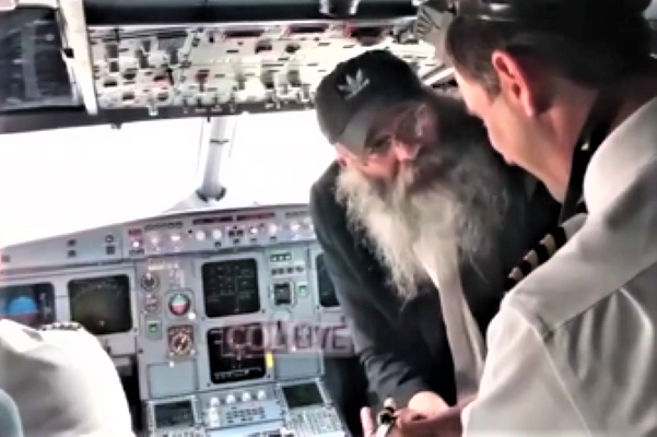 Chabad Rabbi Kalman Weinfeld facilitates a pre-flight bar mitzvah with two pilots. (COLlive/screenshot)