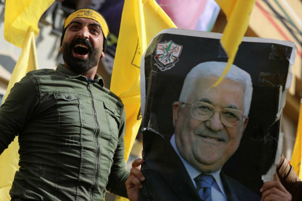 Fatah member with a photo of Mahmoud Abbas