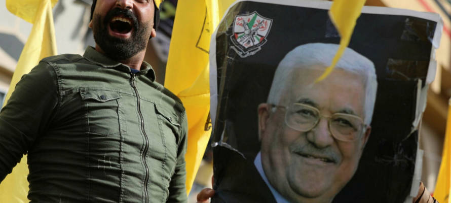 Fatah member with a photo of Mahmoud Abbas