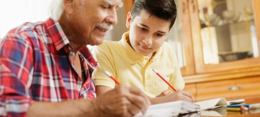 elderly man helps boy with homework