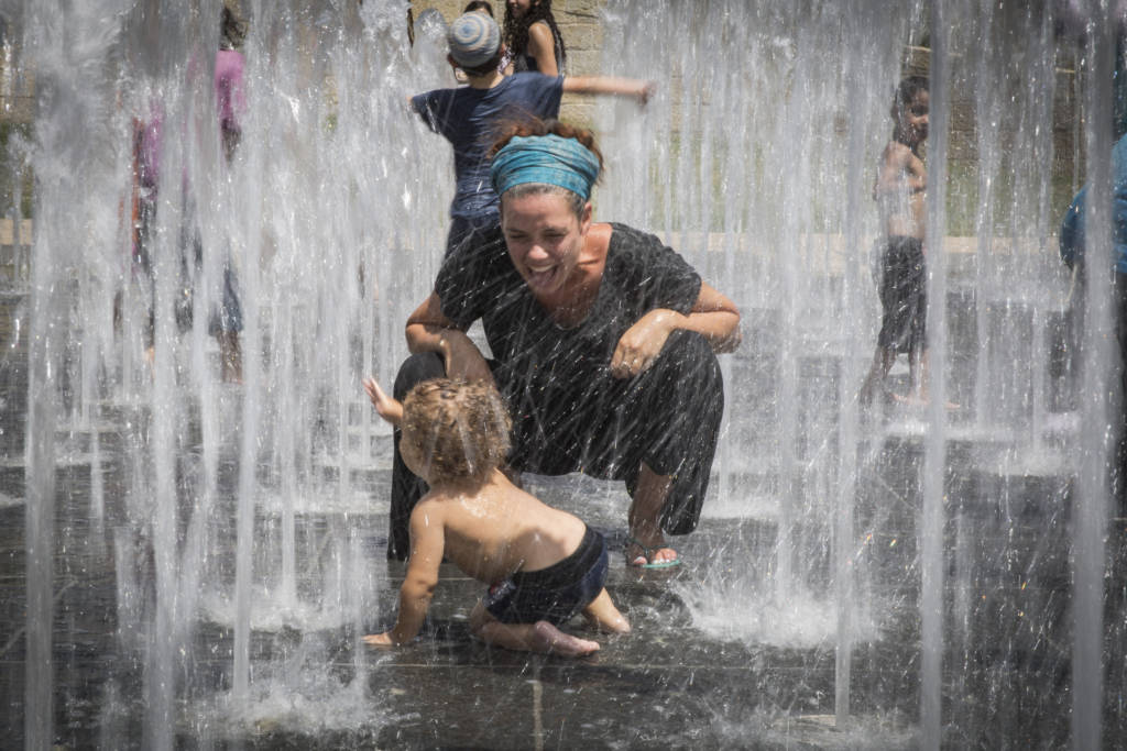 Children play in a water fountain