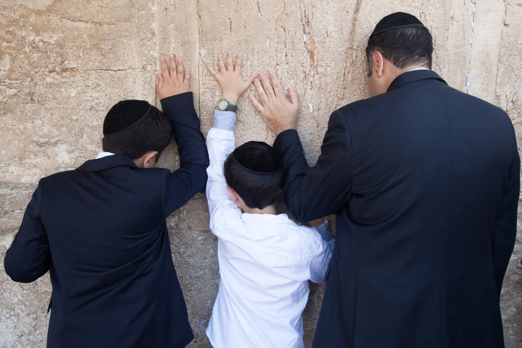 Father and sons pray Western Wall
