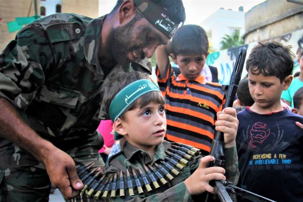 Palestinian boy holds a weapon