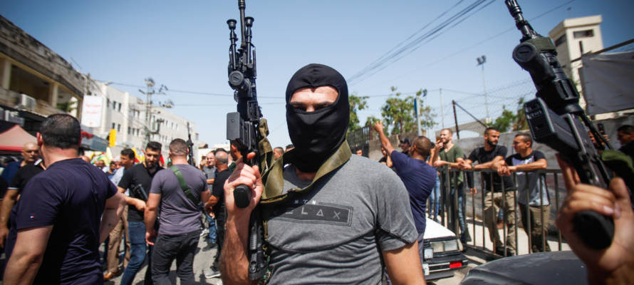 Masked Palestinians hold their guns
