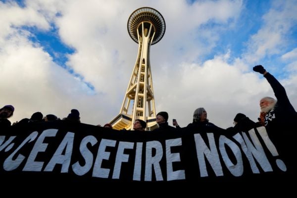 Demonstrators hold up a "Murray: Ceasefire Now!" banner